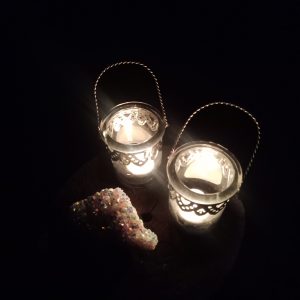 two candle holders and a crystal in the dark, amyra mah
