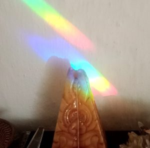 rainbow lights on pyramid-shaped candle, amyra mah